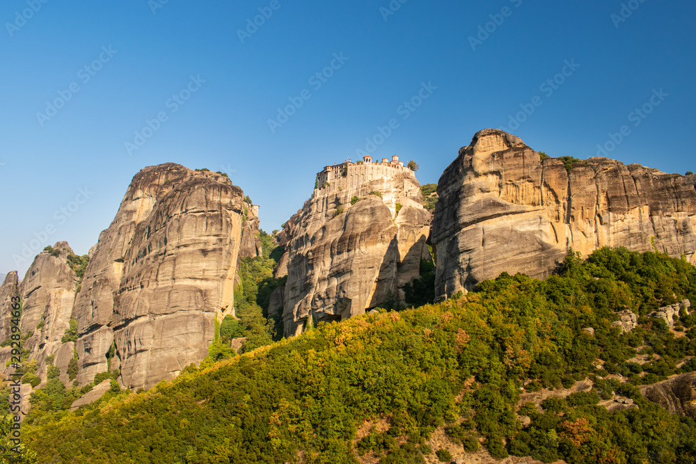 Monastery Meteora Greece. Stunning  panoramic landscape. View of mountains and green forest against epic blue sky with clouds. UNESCO heritage object.