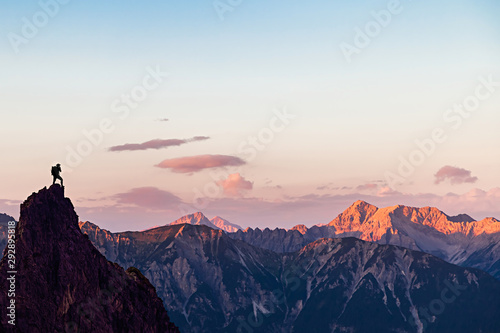 Hiker on top of a Mountain Looking to the Sunset
