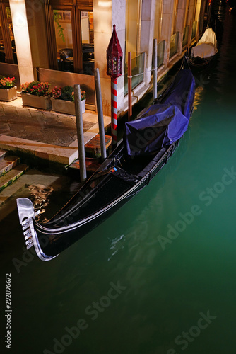 A gondola on the aqua green water of a Venice canal in winter #292896672