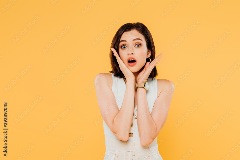 shocked elegant girl with hands near face isolated on yellow shocked elegant girl with hands near face isolated on yellow