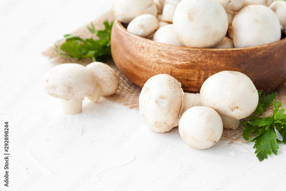 Fresh mushrooms champignon in brown bowl on white background. Fresh mushrooms champignon in brown bowl on white background.