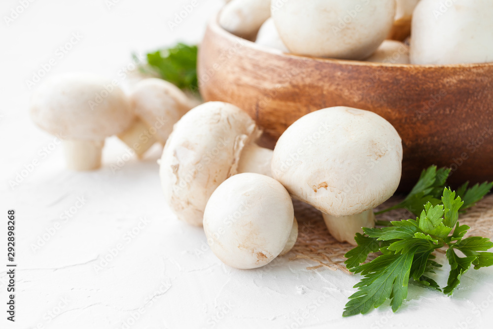 Fresh mushrooms champignon in brown bowl on white background. Fresh mushrooms champignon in brown bowl on white background.