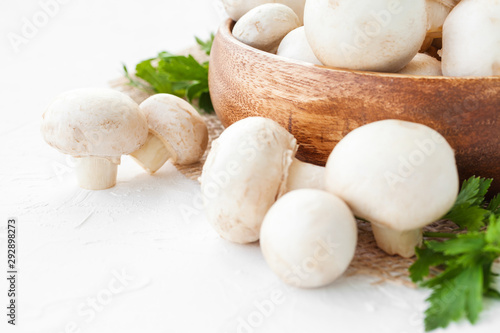 Fresh mushrooms champignon in brown bowl on white background. 