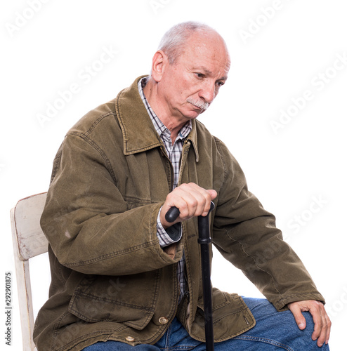 Sad lonely elderly man with a cane sitting  on a chair photo