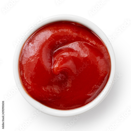 Tomato ketchup in small white ceramic dish isolated on white. Top view. photo