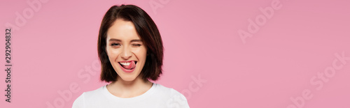 panoramic shot of beautiful girl showing tongue and winking isolated on pink
