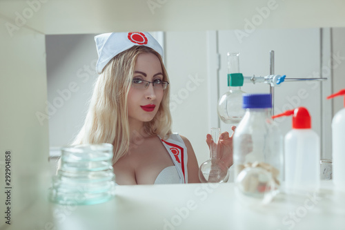 A nurse holds a test tube in her hand, she makes experiments in the laboratory. photo