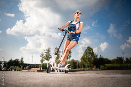 Young beautiful woman riding an electric scooter, modern generation