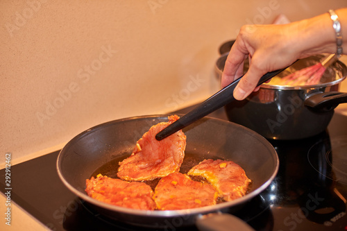  Frying meat in a pan.
