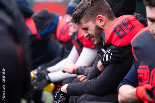 american football player holding the injured shoulder