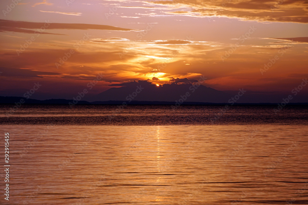 Evening in September. Sunset. Ship silhouette on the horizon. Beautiful view . Greece Sithonia Aegean Sea. Skyline. Horizon. Sky clouds. The setting sun