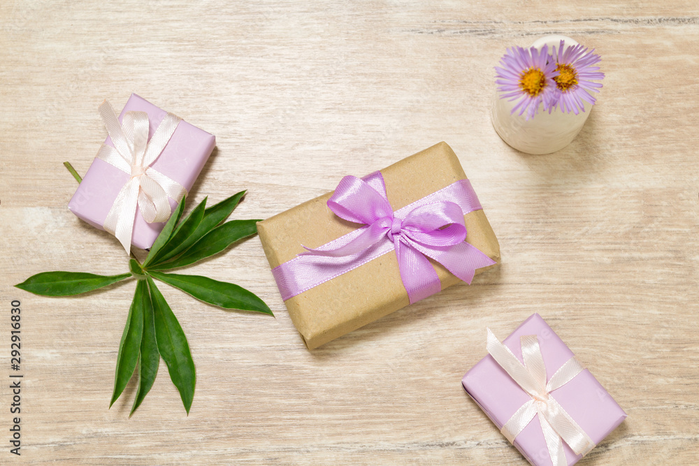 Gift boxes for Mother's Day. Flowers in a vase. Wooden table. The atmosphere of warmth and comfort Gift boxes for Mother's Day. Flowers in a vase. Wooden table. The atmosphere of warmth and comfort