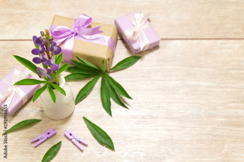 Gift boxes for Mother's Day. Flowers in a vase. Wooden table. The atmosphere of warmth and comfort Gift boxes for Mother's Day. Flowers in a vase. Wooden table. The atmosphere of warmth and comfort