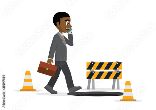 African businessman talking on a cell phone and he does not see the hole in front.
