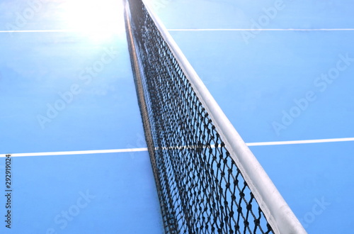 net of tennis court with white border line on blue floor