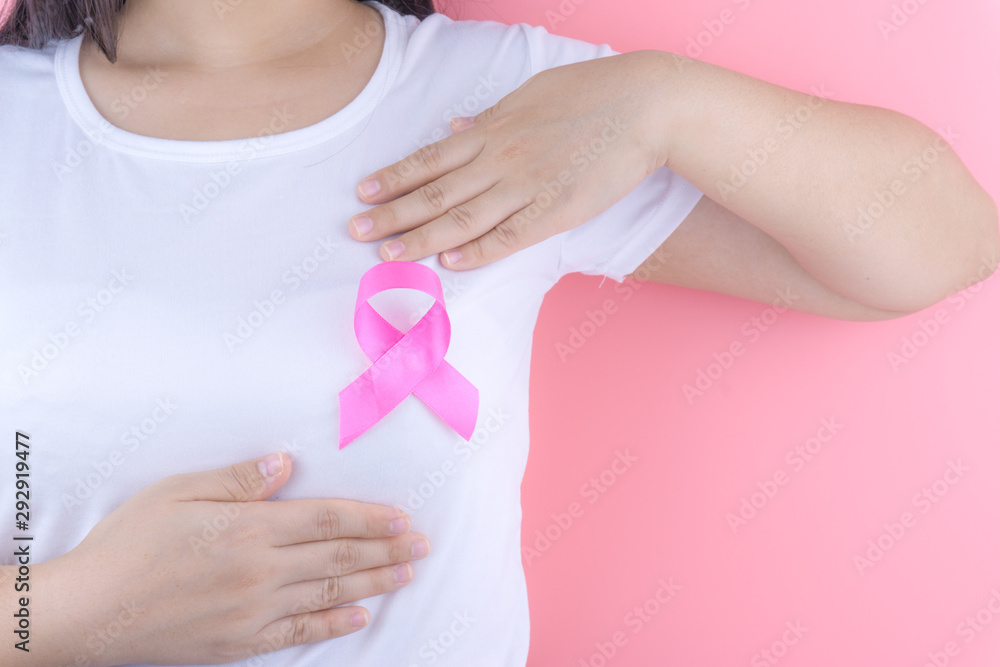 Healthcare, medicine and breast cancer awareness concept. Closeup on woman chest with pink breast cancer awareness ribbon. Healthcare, medicine and breast cancer awareness concept. Closeup on woman chest with pink breast cancer awareness ribbon.