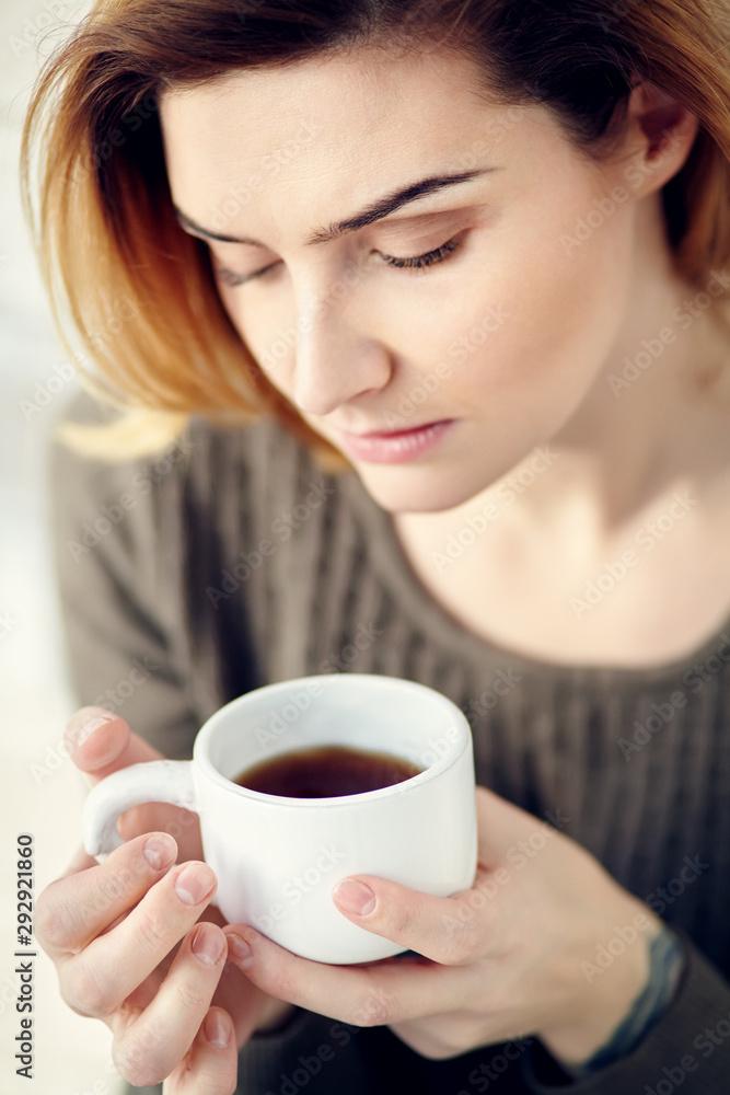 portrait of young attractive smiling woman with a cup of morning coffee or tea. portrait of young attractive smiling woman with a cup of morning coffee or tea.
