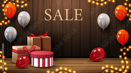 Discount banner with gift boxes, white, orange and red balloons in room on gender near a wooden wall.