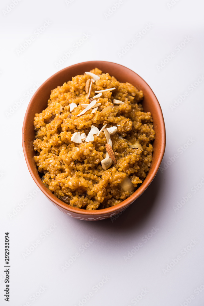 Wheat Laapsi/Lapsi/Shira/Halwa is an Indian sweet dish made of broken wheat or Daliya pieces and ghee along with nuts, raisins and dried fruits. It's a healthy food. served in a bowl, selective focus Wheat Laapsi/Lapsi/Shira/Halwa is an Indian sweet dish made of broken wheat or Daliya pieces and ghee along with nuts, raisins and dried fruits. It's a healthy food. served in a bowl, selective focus