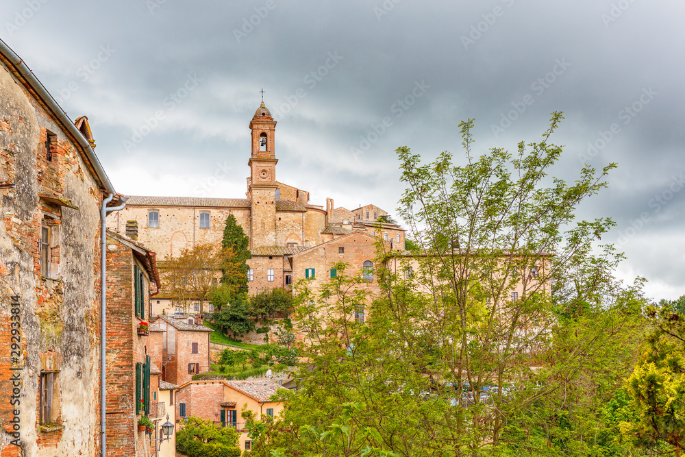 Old Italian rural village on a hill with dark rain clouds