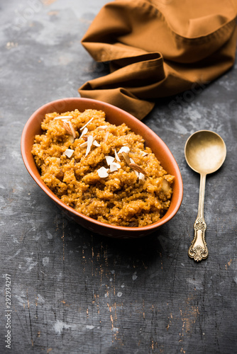 Wheat Laapsi/Lapsi/Shira/Halwa is an Indian sweet dish made of broken wheat or Daliya pieces and ghee along with nuts, raisins and dried fruits. It's a healthy food. served in a bowl, selective focus