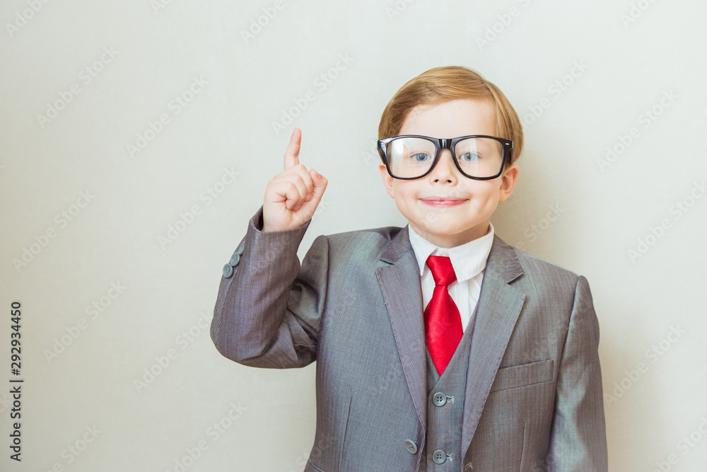 Smiling child boy pointing his index finger at something on white background. Success, creative and innovation business concept Smiling child boy pointing his index finger at something on white background. Success, creative and innovation business concept