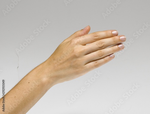 Female right hand posing as if shaking hands or pushing something. Isolated on white