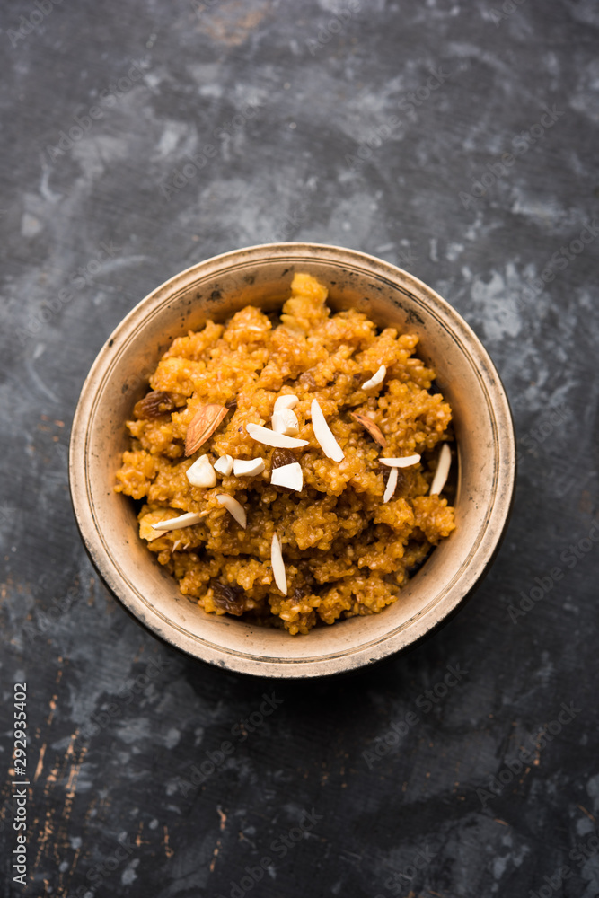 Fototapeta premium Wheat Laapsi/Lapsi/Shira/Halwa is an Indian sweet dish made of broken wheat or Daliya pieces and ghee along with nuts, raisins and dried fruits. It's a healthy food. served in a bowl, selective focus