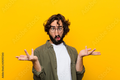 Bilde på lerret young crazy man shrugging with a dumb, crazy, confused, puzzled expression, feel