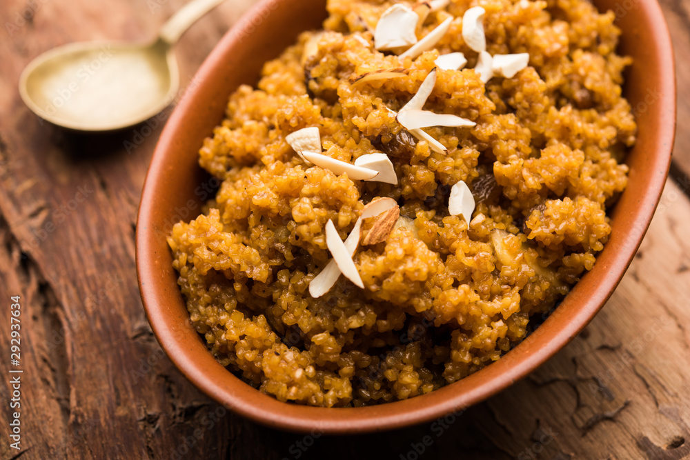 Wheat Laapsi/Lapsi/Shira/Halwa is an Indian sweet dish made of broken wheat or Daliya pieces and ghee along with nuts, raisins and dried fruits. It's a healthy food. served in a bowl, selective focus Wheat Laapsi/Lapsi/Shira/Halwa is an Indian sweet dish made of broken wheat or Daliya pieces and ghee along with nuts, raisins and dried fruits. It's a healthy food. served in a bowl, selective focus
