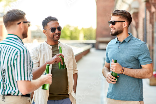 leisure, male friendship and people concept - happy men or friends drinking beer and talking at rooftop party in summer © Syda Productions