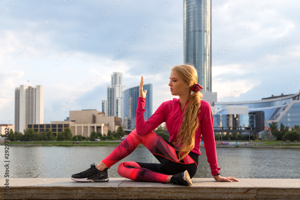 A woman doing exercises at waterfront park with yoga. A woman doing exercises at waterfront park with yoga.