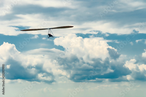 Hang glider wing silhouette and beautiful sky with clouds.