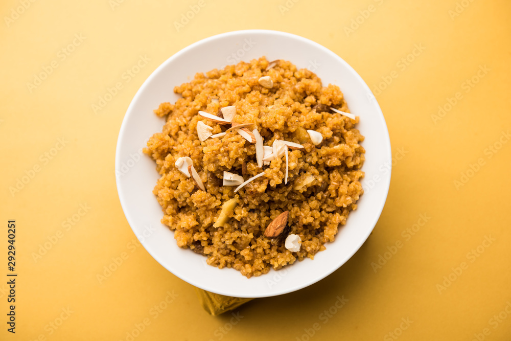 Wheat Laapsi/Lapsi/Shira/Halwa is an Indian sweet dish made of broken wheat or Daliya pieces and ghee along with nuts, raisins and dried fruits. It's a healthy food. served in a bowl, selective focus Wheat Laapsi/Lapsi/Shira/Halwa is an Indian sweet dish made of broken wheat or Daliya pieces and ghee along with nuts, raisins and dried fruits. It's a healthy food. served in a bowl, selective focus