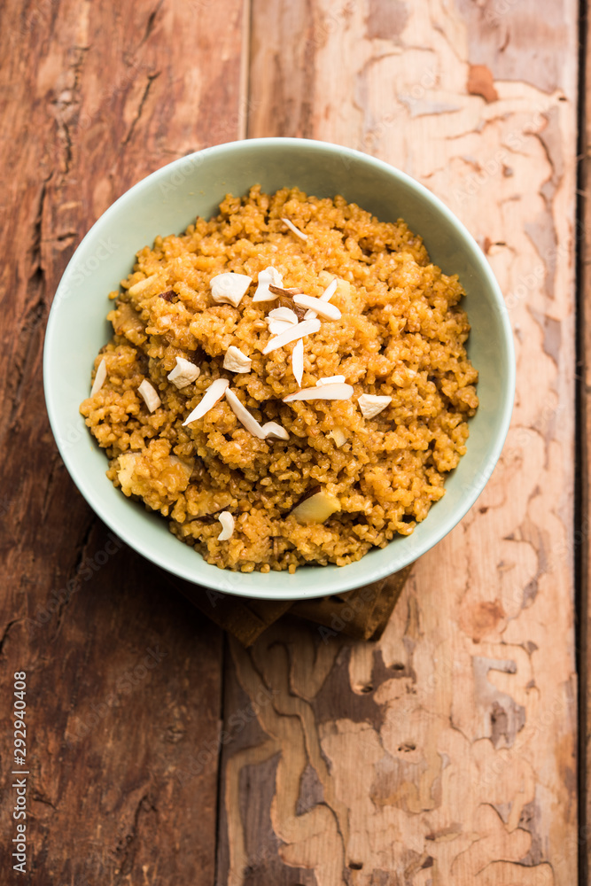 Wheat Laapsi/Lapsi/Shira/Halwa is an Indian sweet dish made of broken wheat or Daliya pieces and ghee along with nuts, raisins and dried fruits. It's a healthy food. served in a bowl, selective focus Wheat Laapsi/Lapsi/Shira/Halwa is an Indian sweet dish made of broken wheat or Daliya pieces and ghee along with nuts, raisins and dried fruits. It's a healthy food. served in a bowl, selective focus