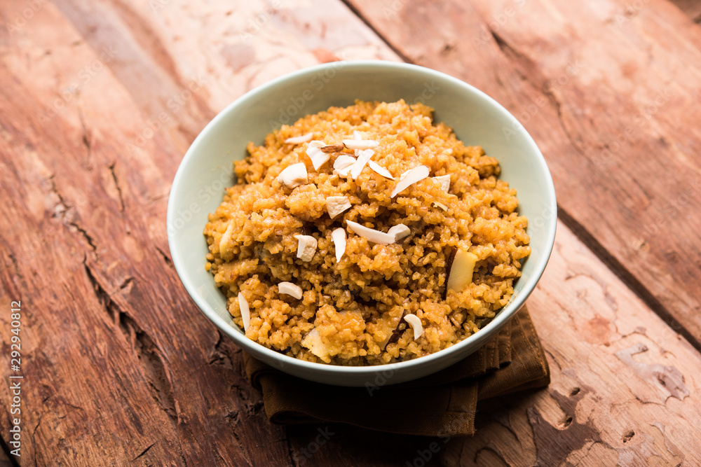 Wheat Laapsi/Lapsi/Shira/Halwa is an Indian sweet dish made of broken wheat or Daliya pieces and ghee along with nuts, raisins and dried fruits. It's a healthy food. served in a bowl, selective focus Wheat Laapsi/Lapsi/Shira/Halwa is an Indian sweet dish made of broken wheat or Daliya pieces and ghee along with nuts, raisins and dried fruits. It's a healthy food. served in a bowl, selective focus
