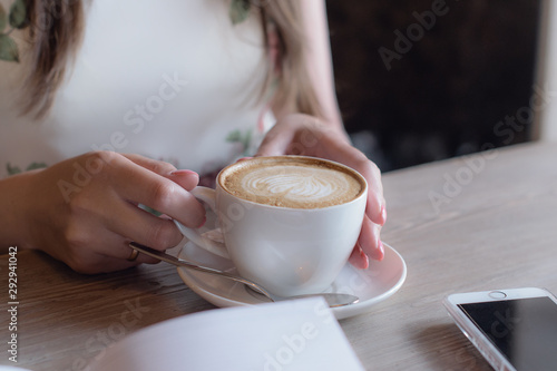 cup of cappuccino in hands
