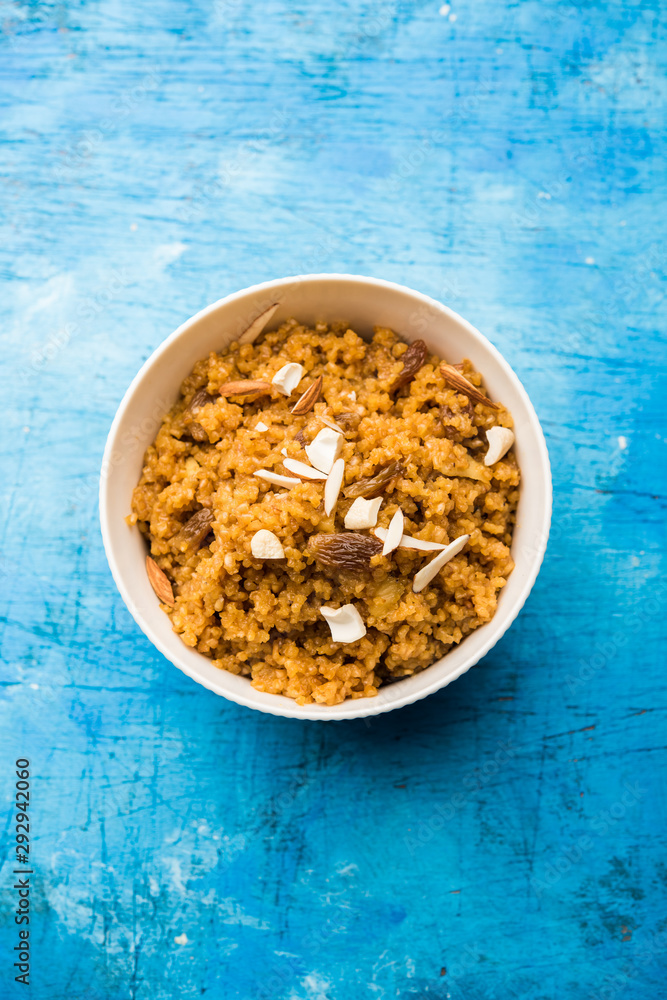 Wheat Laapsi/Lapsi/Shira/Halwa is an Indian sweet dish made of broken wheat or Daliya pieces and ghee along with nuts, raisins and dried fruits. It's a healthy food. served in a bowl, selective focus Wheat Laapsi/Lapsi/Shira/Halwa is an Indian sweet dish made of broken wheat or Daliya pieces and ghee along with nuts, raisins and dried fruits. It's a healthy food. served in a bowl, selective focus