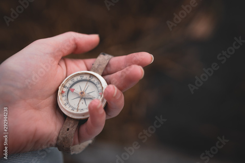 Woman hand holding a old compass with broken glass. Travel concept, path selection, navigation, tourism, hiking. Autumn background. crack on the glass as disappointment and cancellation of plans.