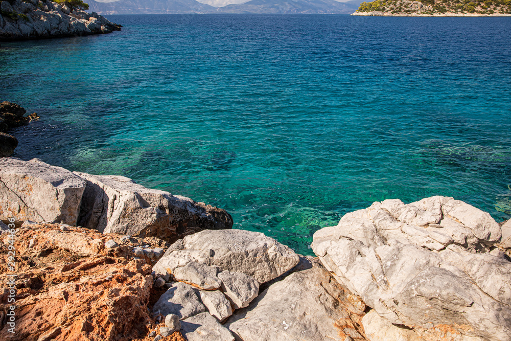 Summer sunny day crystal clear turquoise water and rocky coast of the beautiful Aponissos bay, Agistri island, Saronic Gulf, Greece.