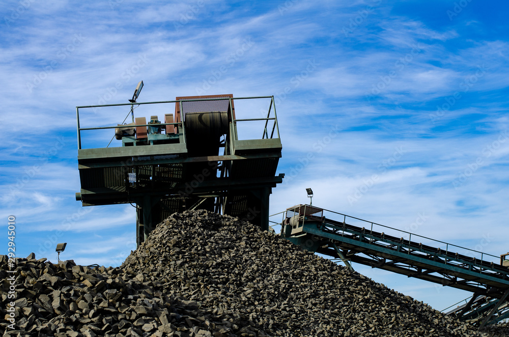 Fototapeta premium Mobile Stone crusher machine by the construction site or mining quarry for crushing old concrete slabs into gravel and subsequent cement production
