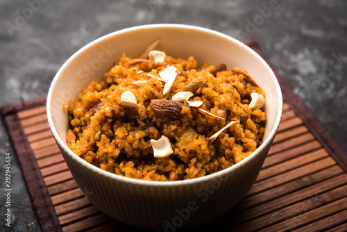 Wheat Laapsi/Lapsi/Shira/Halwa is an Indian sweet dish made of broken wheat or Daliya pieces and ghee along with nuts, raisins and dried fruits. It's a healthy food. served in a bowl, selective focus