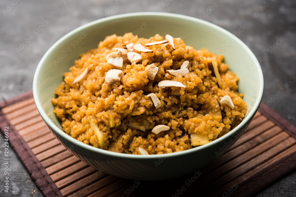 Wheat Laapsi/Lapsi/Shira/Halwa is an Indian sweet dish made of broken wheat or Daliya pieces and ghee along with nuts, raisins and dried fruits. It's a healthy food. served in a bowl, selective focus