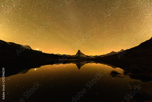 Incredible night view of Stellisee lake with Matterhorn Cervino peak in Swiss Alps. Millions of stars in the pre-bright sky. Zermatt resort location, Switzerland. Landscape astrophotography