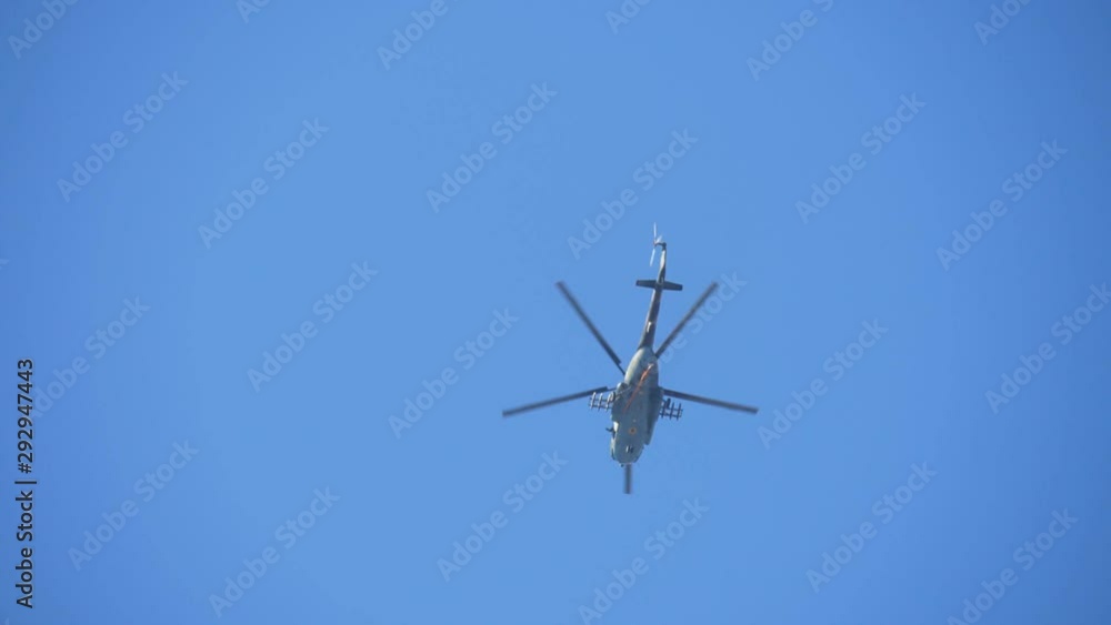 Army copter and a swooping parachutist in the blue air in autumn in slow motion Army copter and a swooping parachutist in the blue air in autumn in slow motion