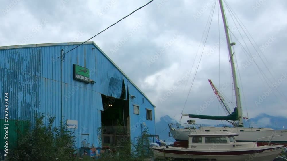 Passenger POV - driving a marine repair shop on the rocky shoreline of Resurrection Bay on Lowell Point; near Seward Alaska and the Kenai Mountains Passenger POV - driving a marine repair shop on the rocky shoreline of Resurrection Bay on Lowell Point; near Seward Alaska and the Kenai Mountains