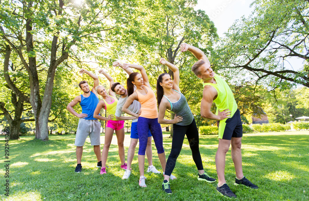 fitness, sport and healthy lifestyle concept - group of happy people exercising at summer park or boot camp fitness, sport and healthy lifestyle concept - group of happy people exercising at summer park or boot camp