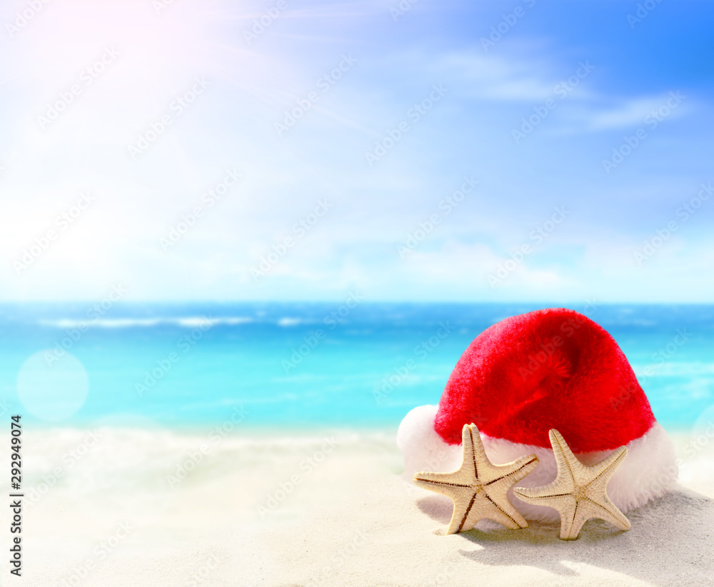 Christmas holidays concept. Santa claus hat on summer sand beach. Christmas holidays concept. Santa claus hat on summer sand beach.
