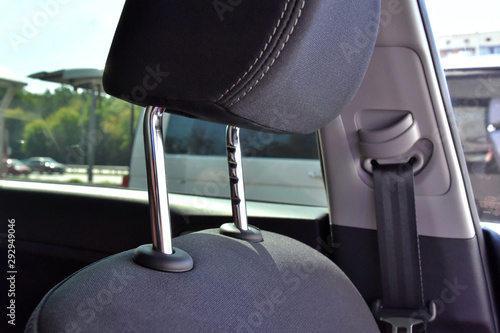 Element of car headrest with metal protect element, selective focus and blurred sea belt on background. Automobile interior with part of headrest. chrome protection element. passenger safety in a car.