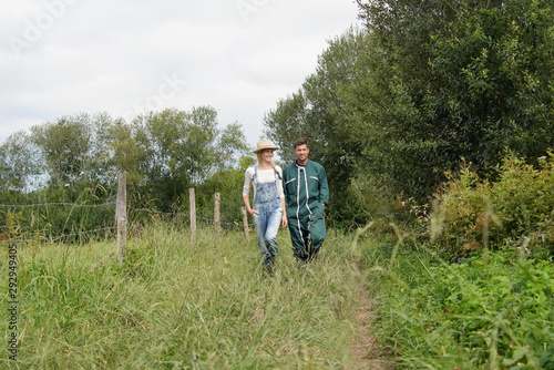 Couple of farmers walking in field © goodluz